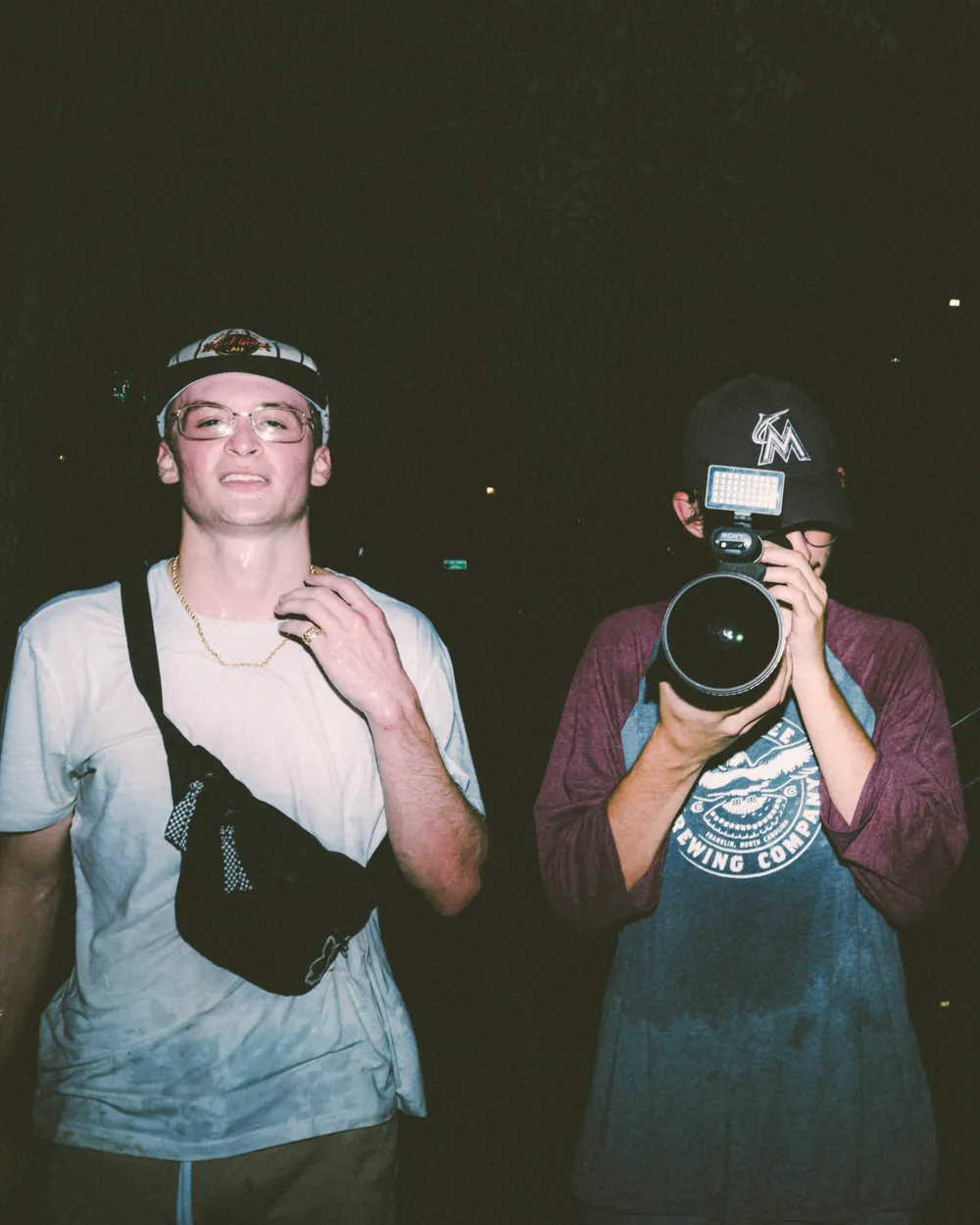 Two friends at night, one shooting back at the camera